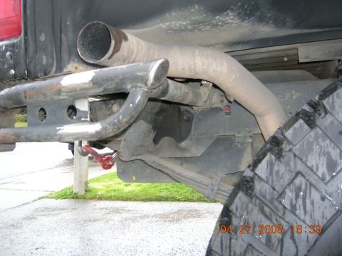 1996 Ford Bronco - Close-up of a vehicle's rear bumper, tow hook, and exhaust system.
