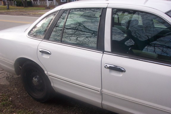 White sedan side view, showing chrome door handles and trim. Black steel wheels visible