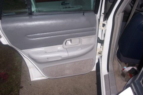 1996 Ford Crown Victoria - Interior view of a car door panel, including the handle and armrest.