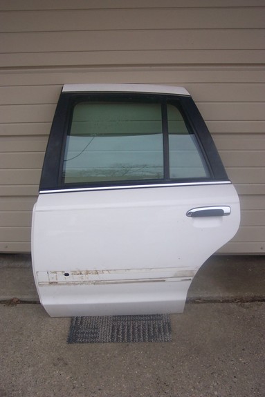 1996 Ford Crown Victoria - Rear passenger door from a 1996 Ford Crown Victoria, a chrome door handle and tinted window.
