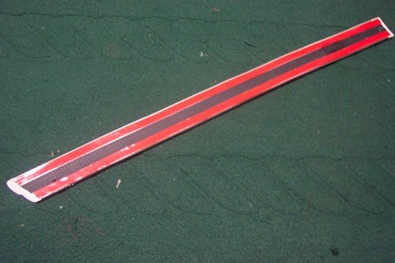 Red and black trim piece with textured black stripe