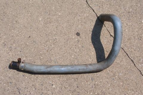 1996 Ford Crown Victoria - A metal oil cooler hose with a black fitting and clamp is shown on a concrete surface.
