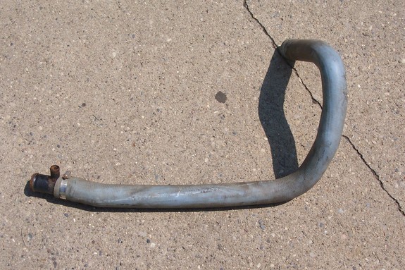 Metal oil cooler hose with black fitting and clamp, lying on concrete