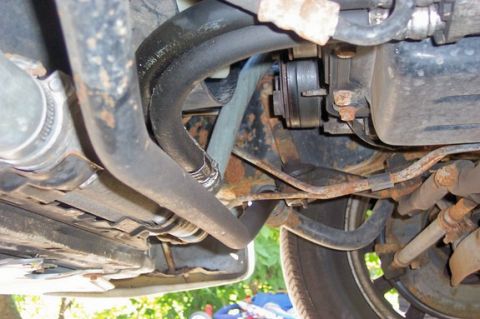 1996 Ford Crown Victoria - Close-up view of vehicle undercarriage components, showing hoses and suspension parts.