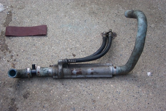 Oil cooler assembly with hoses and a piece of sandpaper on concrete