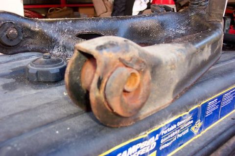 1996 Ford Crown Victoria - A close-up of a heavily rusted car suspension part rests on a surface with a generator advertisement.