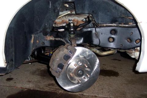 1996 Ford Crown Victoria - Close-up view of a vehicle's front wheel brake assembly, showing a new rotor and caliper.
