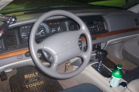 1996 Ford Crown Victoria - The interior of a 1996 Ford Crown Victoria, showing the dashboard, steering wheel, and floor mats.