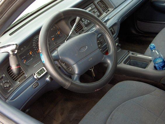 1996 Ford Crown Victoria interior showing dashboard, steering wheel, and center console with a water bottle