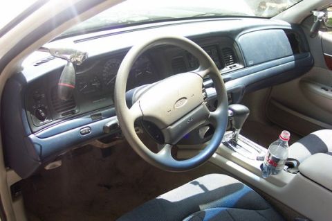 1996 Ford Crown Victoria - The dashboard and interior of a car are visible, including the steering wheel and center console.