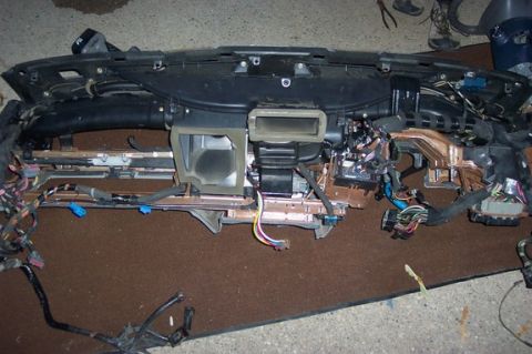 1996 Ford Crown Victoria - Disassembled dashboard assembly showing the intricate wiring harness and HVAC ducting.