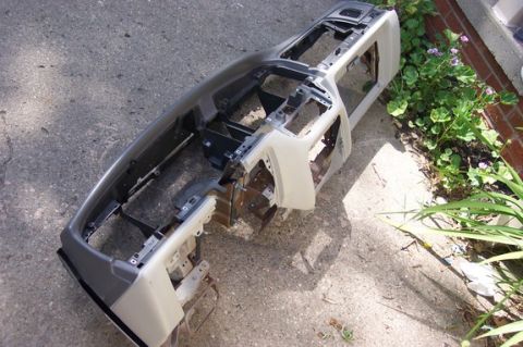 1996 Ford Crown Victoria - Dashboard frame assembly removed from a vehicle and placed outdoors on concrete.
