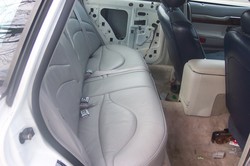 1996 Ford Crown Victoria - The interior of a car shows the rear seats and door panels removed, revealing the car's inner workings.