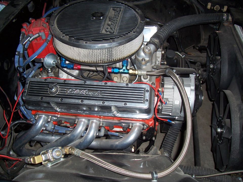 Engine bay with V8 engine, chrome valve covers, air filter, and radiator fan