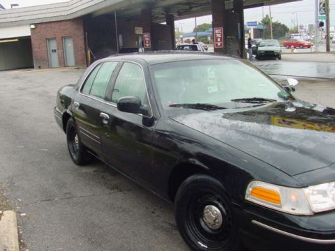1998 Ford Crown Victoria - This 1998 Ford Crown Victoria is parked in front of a brick building with covered awnings.