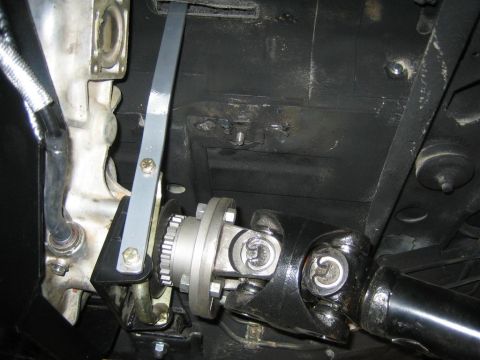 1987 Suzuki Samurai - Underside view of a vehicle's transfer case linkage and driveshaft components.