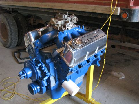 1980 Ford F-250 - A blue Ford V8 engine with chrome valve covers sits on a yellow stand.