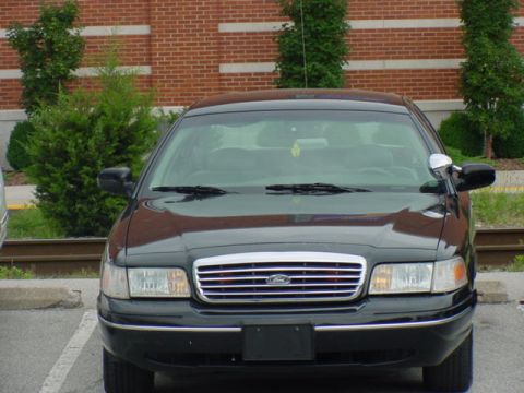 1998 Ford Crown Victoria - A black 1998 Ford Crown Victoria is shown from the front, its distinctive chrome grille and headlights.