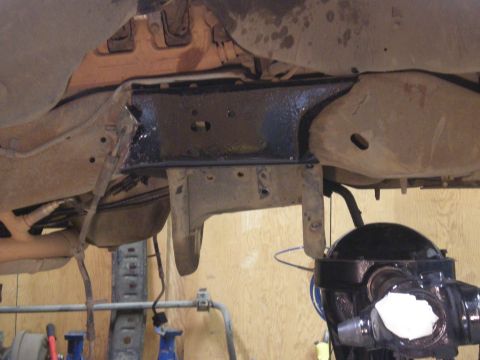 1993 Ford Bronco - Close-up view of the undercarriage, focusing on suspension components and a painted crossmember.