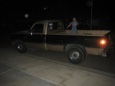 1999 Ford F-250 - A two-tone pickup truck is parked at night with a person standing in its bed.