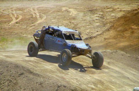 2008 Ford Bronco - A custom-built off-road buggy navigates a dusty, uneven terrain.