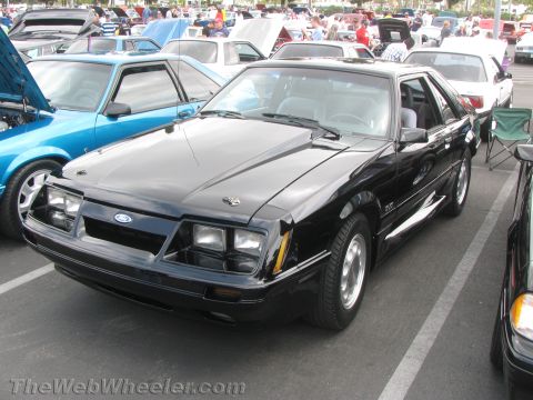 1968 Ford Mustang - This black Ford Mustang coupe features a prominent hood scoop and GT badging, indicating it is likely a 1985 model.