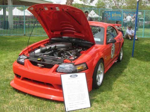 1968 Ford Mustang - This red Ford Mustang has its hood open, revealing the engine and a descriptive sign in front.