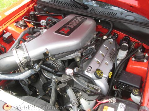 1968 Ford Mustang - Close-up view of a V8 32-valve engine with a Cobra emblem on the intake manifold.