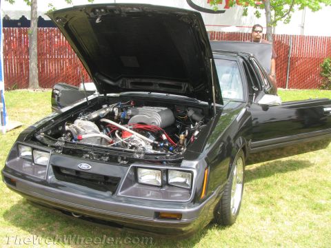 1968 Ford Mustang - Customized black Ford Mustang with engine exposed and driver's door ajar.