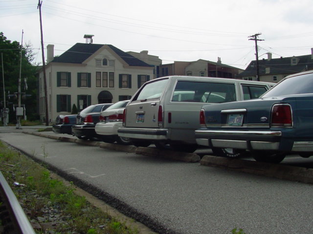1998 Ford Crown Victoria and other cars parked side-by-side on a street