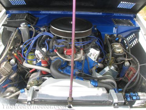 1968 Ford Mustang - The engine bay features vibrant blue paint, chrome components, and an aftermarket air filter, suggesting a modified vehicle.