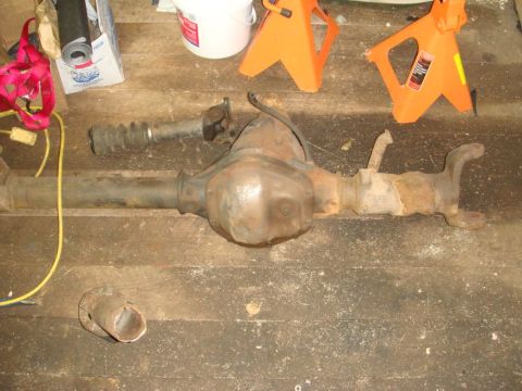 1996 Ford Bronco - A rusty rear axle assembly, likely from a truck or SUV, is shown with its associated driveshaft and U-joint.