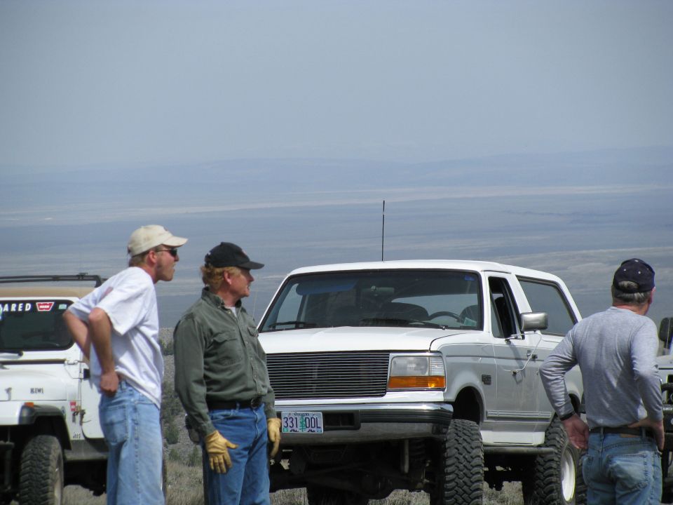 White Ford Bronco with billet grille and Oregon plate 331 DDL on a ridge with three men