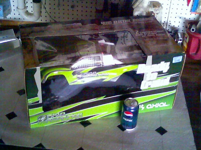 RC electric monster truck in box with Pepsi can
