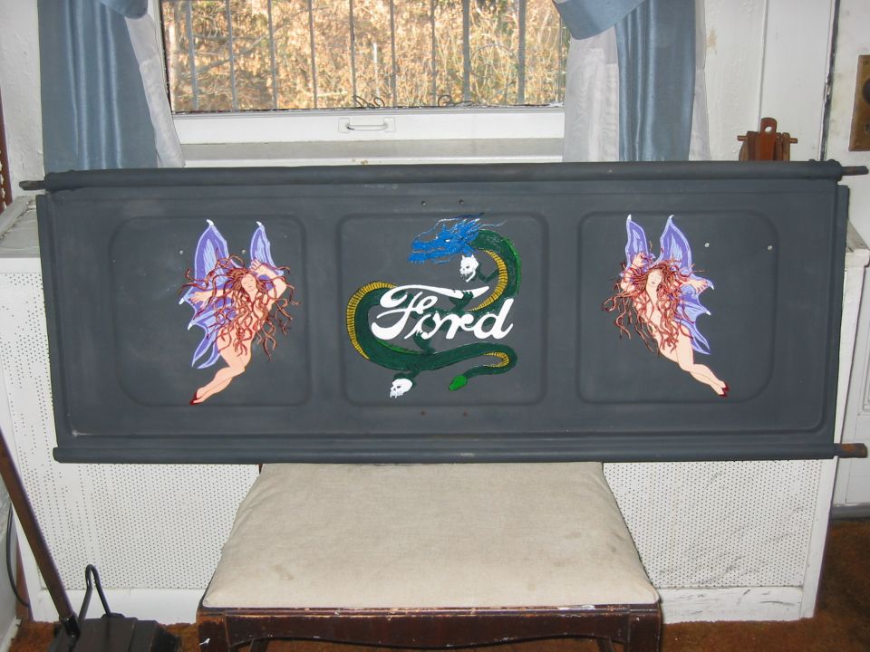 Gray Ford tailgate hand-painted with two fairies and a dragon coiled around the Ford script