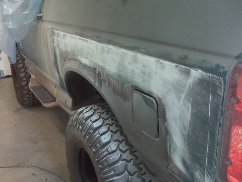 1996 Ford Bronco - Photograph of a truck bedside panel during bodywork and primer prep, not a technical document.