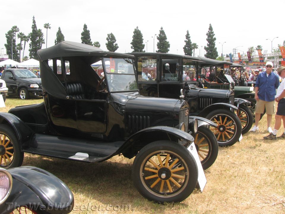 Row of black vintage Ford Model T cars lined up at a car show