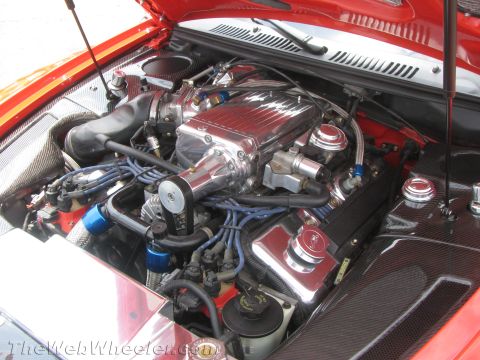 1968 Ford Mustang - Photograph of a polished supercharged engine bay in a red car with carbon-fiber fenders.