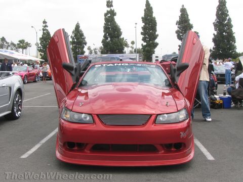 1968 Ford Mustang - A red car is parked with its distinctive lambo doors open, viewed from the front.