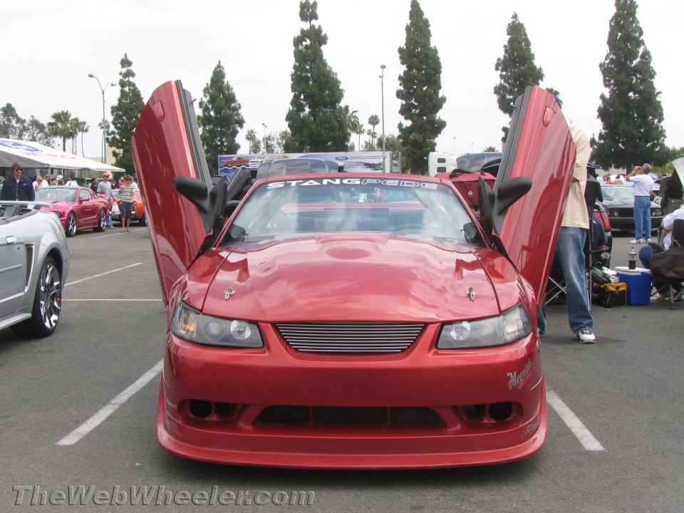 Red car with lambo doors open, front view