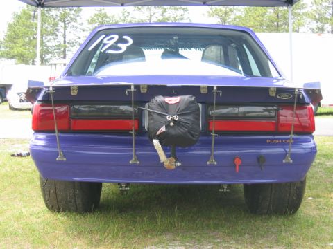 1992 Ford Mustang - Rear view of a purple 1992 Ford Mustang drag car, modified with a large spoiler and drag chute.