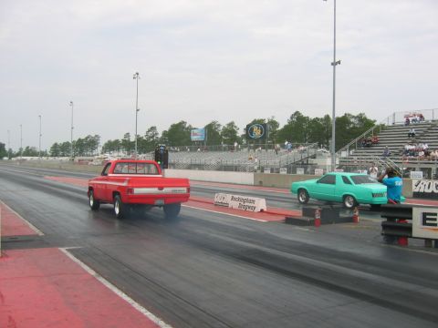 1992 Ford Mustang - Two vehicles, a red pickup and a teal coupe, are staged on a drag strip at Rockingham Dragway.