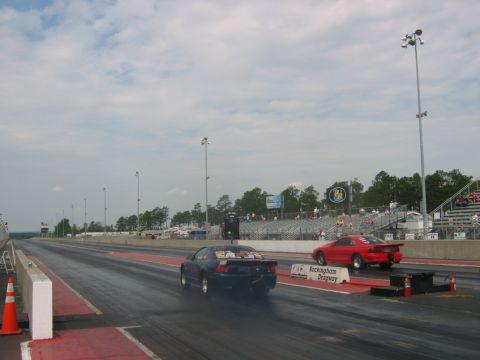 1992 Ford Mustang - Two cars compete at Rockingham Dragway under a cloudy sky.