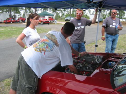 1992 Ford Mustang - Mechanics and onlookers examine the engine of a red 1992 Ford Mustang at Rockingham Dragway.