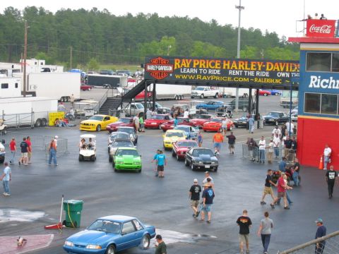 1992 Ford Mustang - A crowd gathers around various cars at a drag strip event, with a green 1992 Ford Mustang prominently visible.