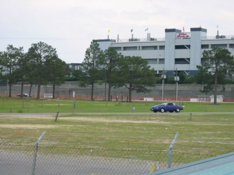 1992 Ford Mustang - A purple coupe with a rear spoiler is seen driving on the track at Rockingham Dragway, with the grandstands in the background.