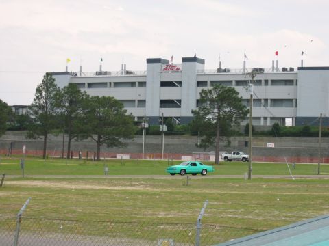 1992 Ford Mustang - Two vehicles drive past the grandstands at Rockingham Dragway.