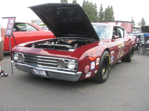 1968 Ford Mustang - A maroon 1969 race car is displayed with its hood open, showing off its engine and racing decals.