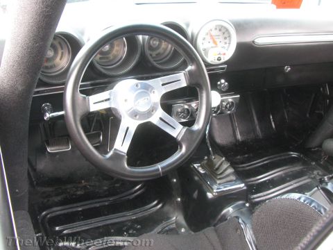 1968 Ford Mustang - The interior of a 1968 Ford Mustang features a custom steering wheel and a prominent tachometer on the dashboard.