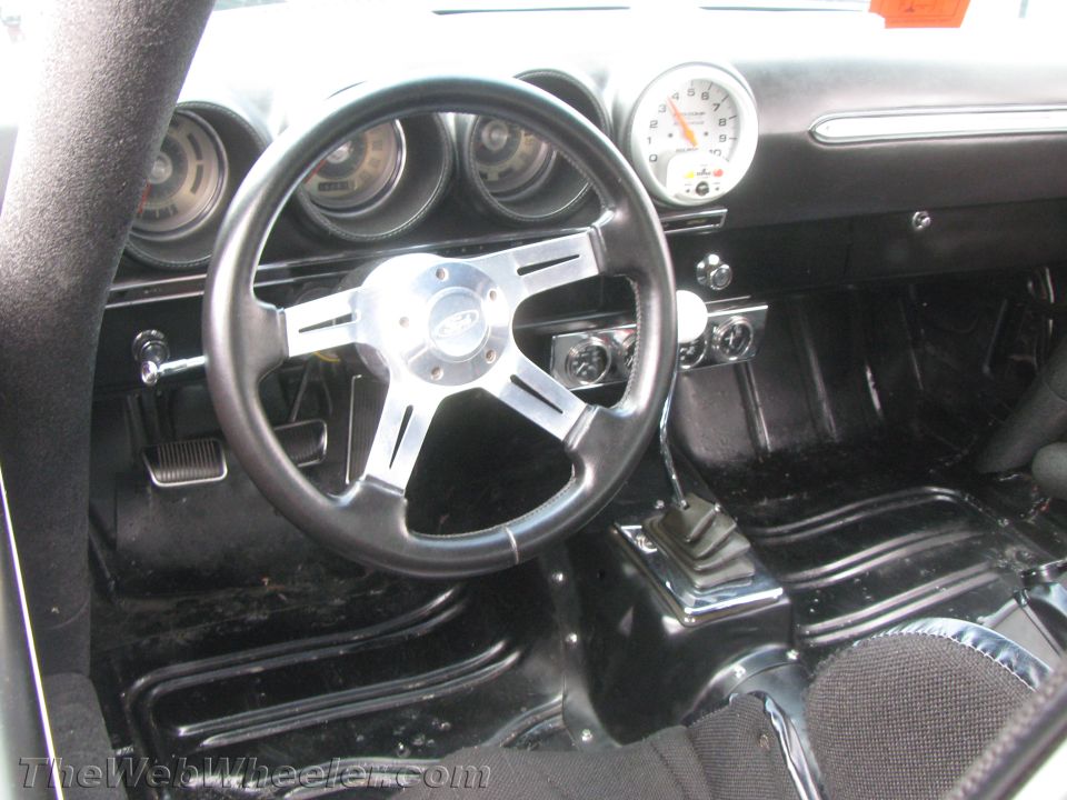 1968 Ford Mustang interior with aftermarket steering wheel and tachometer